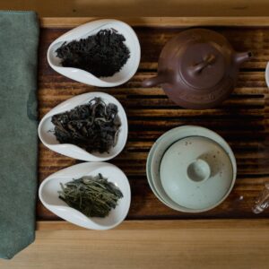 Artistic setup of a traditional Asian tea ceremony with cups, teapots, and tea leaves.
